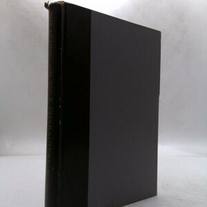 May include: A hardcover book with a dark gray cover and a black spine. The spine has the title "Preaching on Bible Characters" printed vertically in gold lettering. The book is slightly angled, showing its pages.