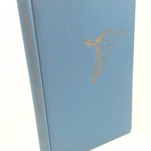 May include: A blue book with the title "A COVERED SKY FOR THE REMNANT OF THE WORLD" by Scott A.  Smith. The cover features a gold silhouette of a bird in flight.