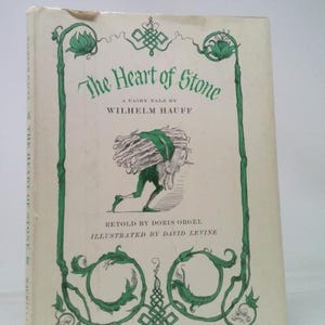 May include: A white ceramic mug with a black handle and the text "But First, Coffee" in a black, bold font. The mug is sitting on a wooden surface. The mug is approximately 4 inches tall.