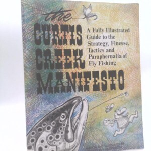 May include: A softcover book titled The Curtis Creek Manifesto: A Fully Illustrated Guide to the Strategy, Finesse, Tactics and Paraphernalia of Fly Fishing. The cover features a large fish head, a fly fishing lure, and a cartoon angler illustration.