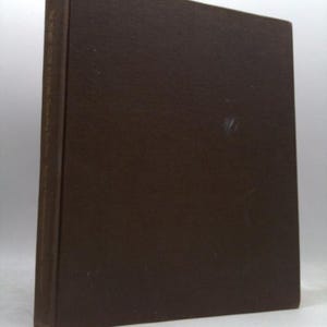 May include: A dark brown hardcover book with a solid, textured cover. The spine features vertical text that reads The Time-Life Book at Home, Decorating for Men, and includes additional text that is partially obscured and difficult to read.