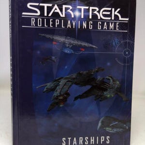 May include: A blue book with the title "Star Trek Roleplaying Game" and a picture of a spaceship on the cover. The book also says "Starships" at the bottom.