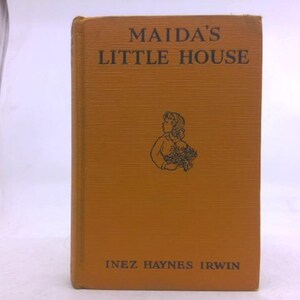 May include: A vintage book titled "Maida's Little House" by Inez Haynes Irwin. The cover is a textured orange with black text and a small illustration of a girl holding flowers. The book is in good condition.