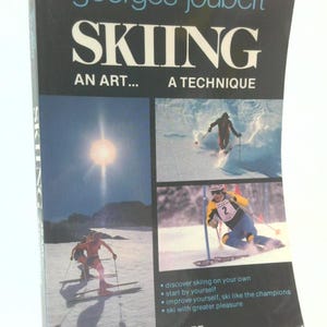 May include: A book cover for "Skiing: An Art... A Technique" by Georges Joubert. The cover is black with white and blue text and features action shots of skiers. The book promises to help readers discover skiing, improve skills, and ski with greater pleasure.