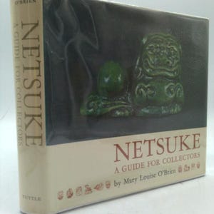 May include: A book titled "Netsuke: A Guide for Collectors" by Mary Louise O'Brien. The cover features a dark background with two green Netsuke sculptures. The spine displays the title and author's name.