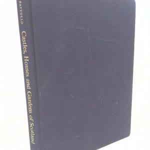 May include: A navy blue book titled "Castles, Houses and Gardens of Scotland" by Pattullo. The book's spine features gold lettering. The book is slightly angled, showcasing its cover and spine.