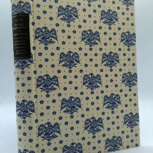 May include: A hardcover book titled "The Life of Washington" with a cream-colored cover featuring a repeating pattern of blue eagles and stars. The spine is black with white text.