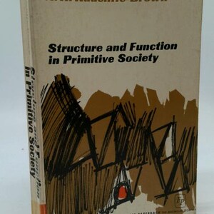 May include: A vintage paperback book titled "Structure and Function in Primitive Society" by A.R. Radcliffe-Brown. The cover is beige with black and brown abstract illustrations. The book's spine also displays the title.