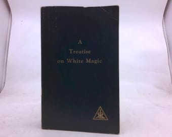 Puede incluir: Un libro azul oscuro titulado "A Treatise on White Magic" con letras doradas. El libro tiene un símbolo de triángulo dorado en la parte inferior. El libro está de pie.