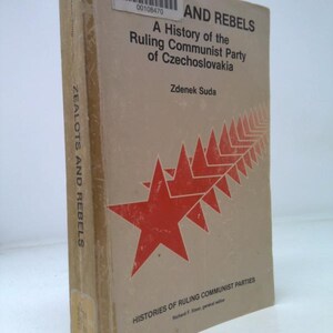 May include: A hardcover book titled "AND REBELS A History of the Ruling Communist Party of Czechoslovakia" by Zdenek Suda. The book has a tan cover with red star graphics and text. The spine reads "ZEALOTS AND REBELS".