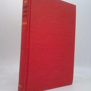 May include: A hardcover book with a bright red cover. The book's spine displays the title and author's name in gold lettering. The cover has a textured appearance. The book is standing upright.