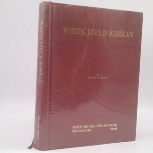 May include: A maroon hardcover book titled "WHITE FIELD KOREAN" with gold lettering. The author's name, Bruce R. Grant, is below the title. The book's spine also displays the title and author. The publisher's information is at the bottom.