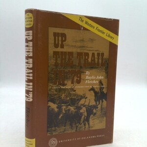 May include: A brown book with the title "Up the Trail in '79" by Baylis John Fletcher. The book is part of The Western Frontier Library series and is published by the University of Oklahoma Press.