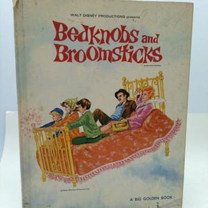 May include: A vintage "Bedknobs and Broomsticks" book cover. The cover features the title in red script above an illustration of characters on a flying bed. The book is a "Big Golden Book" from Walt Disney Productions.
