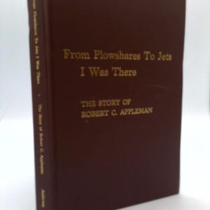 May include: A hardcover book with a dark brown cover. The title "From Plowshares To Jets I Was There" is printed in gold lettering. The author's name, Robert C. Appleman, is also in gold. The book's spine also has text.