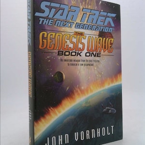 May include: A book cover for "Star Trek: The Next Generation: The Genesis Wave, Book One" by John Vorholt. The cover features a fiery orange and yellow explosion with a planet in the background. The text "Star Trek: The Next Generation" is in blue and the text "The Genesis Wave" is in yellow.