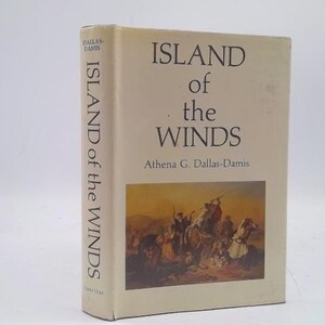 May include: A hardcover book titled "ISLAND of the WINDS" by Athena G. Dallas-Damis. The book has a beige cover with the title in large, dark letters. A colorful illustration of people on horseback is on the front cover.