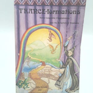 May include: A vintage book titled "TRANCE-formations" with a colorful illustration. The cover art features a rainbow, dragons, and a figure in a robe. The book's subtitle is "Neuro-Linguistic Programming and the Structure of Hypnosis."