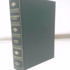 May include: A hardcover book titled "Canterbury Tales" by Geoffrey Chaucer. The spine is dark green with gold lettering and decorative elements. The book is standing upright on a white surface.