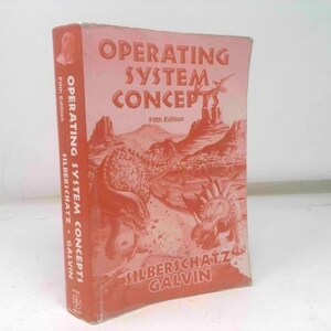 May include: A vintage book titled "Operating System Concepts, Fifth Edition" by Silberschatz and Galvin. The cover is a faded reddish-orange with illustrations of dinosaurs and a desert landscape. The book is standing upright.