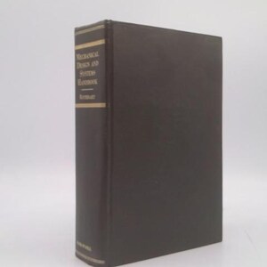May include: A hardcover book titled "Mechanical Design and Systems Handbook" with a dark brown cover and gold lettering. The book is standing upright against a white background.
