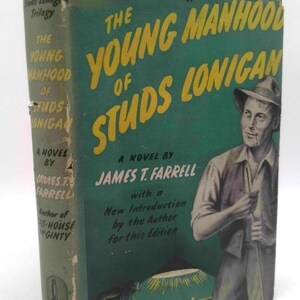 May include: Vintage hardcover book titled "The Young Manhood of Studs Lonigan" by James T. Farrell. The cover is a teal green with yellow lettering and a portrait of a man in a hat. The book is part of a trilogy.
