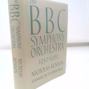 May include: A hardcover book titled "The BBC Symphony Orchestra 1930-1980" by Nicholas Kenyon. The book has a light beige cover with teal lettering. The title and author's name are prominently displayed on the front and spine.