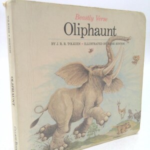 May include: A vintage hardcover book titled "Oliphaunt" by J.R.R. Tolkien, illustrated by Hank Hinton. The cover features a large, light gray elephant with large ears and tusks, running across a landscape with other animals.