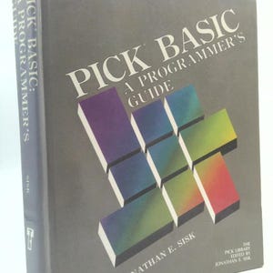 May include: A hardcover book titled "PICK BASIC: A Programmer's Guide" by Jonathan E. Sisk. The cover is gray with the title in large white letters and a colorful geometric design. The book's spine also displays the title.