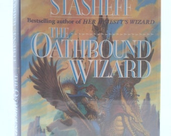 May include: A book cover with a blue and green background featuring a dragon flying through the air with a person riding on its back. The book title is "The Oathbound Wizard" and the author is Christopher Stasheff. The book cover also includes the text "Bestselling author of Her Majesty's Wizard."