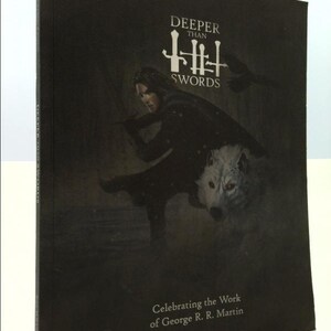May include: A black book cover with the title "Deeper Than Swords" in white text. The cover features a woman with a sword and a white wolf with red eyes. The text "Celebrating the Work of George R. R. Martin" is at the bottom of the cover.