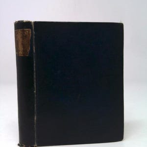 May include: A hardcover book with a dark blue cover. The spine has a gold label. The book is standing upright against a white background. The edges of the book show signs of wear.