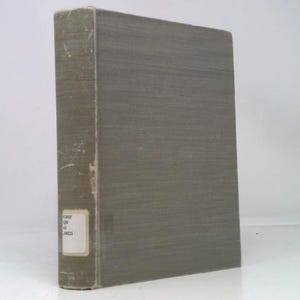 May include: A vintage book with a weathered, gray cover. The spine is lighter in color and shows signs of wear. A small, rectangular label with text is affixed to the spine. The book is standing upright against a white background.