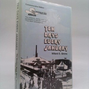 May include: A book titled "Ten Days Every January" by Willard E. Simms. The cover features a black and white illustration of a crowd and buildings, with text in a bold font. The book is a commemorative edition.