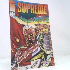 May include: A comic book titled "Supreme" with a dynamic illustration of a muscular, blond-haired character in a red cape. The cover features bold yellow and blue lettering and the Image Comics logo.