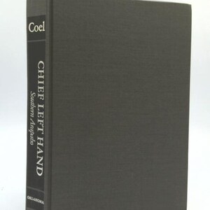 May include: A hardcover book titled "Chief Left Hand Southern Arapaho" by Coel. The book has a dark gray cover and spine with white text. The word "Oklahoma" is printed at the bottom of the spine.