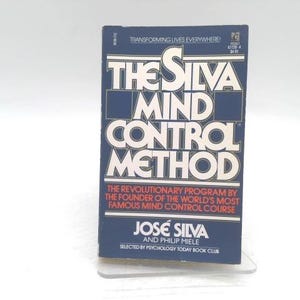 May include: A book titled "The Silva Mind Control Method" with a navy blue cover and white lettering. The book's title is prominently displayed, along with the author's name, José Silva, and the phrase "Transforming Lives Everywhere!"