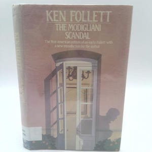 May include: A book cover with a pink background and the title "Ken Follett The Modigliani Scandal". The cover features a drawing of a doorway with a person standing in the doorway.