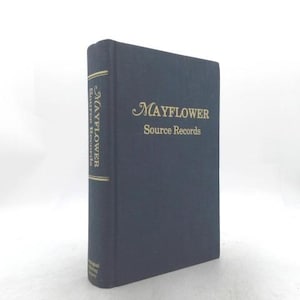 May include: A dark blue hardcover book titled Mayflower Source Records with gold lettering on the front cover and spine. The spine also features gold horizontal lines and small text at the bottom, presenting a clean and structured appearance.