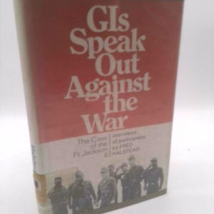 May include: A red book titled "GIS Speak Out Against the War" with a photo of soldiers on the cover. The book is about the Case of the Ft Jackson 8.