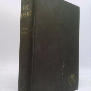 May include: A dark green hardcover book titled "THE HERETIC" with gold lettering. The author's name, Fitzroy Maclean, is printed below the title. The book has a textured cover and a gold emblem on the lower right corner.