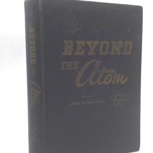 May include: A dark blue book titled "Beyond the Atom" with gold lettering and atom illustrations. The spine also features the title. The author's name, John Dyrkiel, Ph.D., is printed below the title.