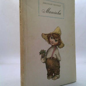 May include: Vintage book titled "Maminka" by Jaroslav Seifert. The cover features an illustration of a child wearing a straw hat and overalls, holding flowers. The book has a light-colored cover with text in a blue box.