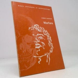 May include: An orange book titled "Warfare" by Robert Harrison, part of the "basic concepts in anthropology" series. The cover features a white illustration of a human face and a skull.