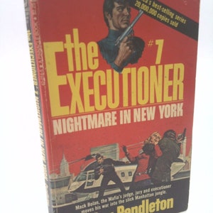 May include: A red and black paperback book cover with the title "The Executioner #7 Nightmare in New York" by Don Pendleton. The cover features a man holding a gun and a helicopter in the background.