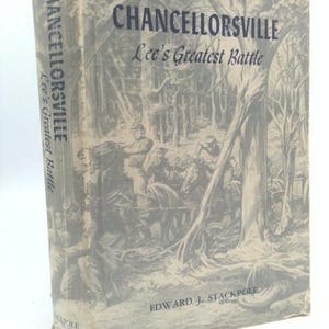 May include: A hardcover book titled "Chancellorsville Lee's Greatest Battle" by Edward J. Stackpole. The cover features a grayscale illustration of soldiers and horses in a forest setting. The book's spine also displays the title.