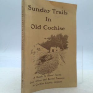 May include: A vintage book cover with a tan background and brown text. The title is "Sunday Trails in Old Cochise" and the subtitle is "A Guide to Ghost Towns, Lost Mines and Buried Treasure in Cochise County, Arizona".