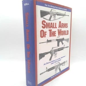 May include: A hardcover book titled "Small Arms of the World" with a blue spine and red trim. The cover features illustrations of various firearms and the text "The 12th Edition Fully Updated and Revised."