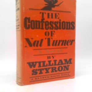 May include: A hardcover book titled "The Confessions of Nat Turner" by William Styron. The book has an orange cover with dark brown lettering. The title is prominently displayed, and the author's name is below. A Random House Book.