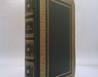 May include: A vintage hardcover book titled "The Talisman" by Sir Walter Scott. The book has a dark green cover with gold decorative accents and text. The spine features the title and author's name in gold lettering.